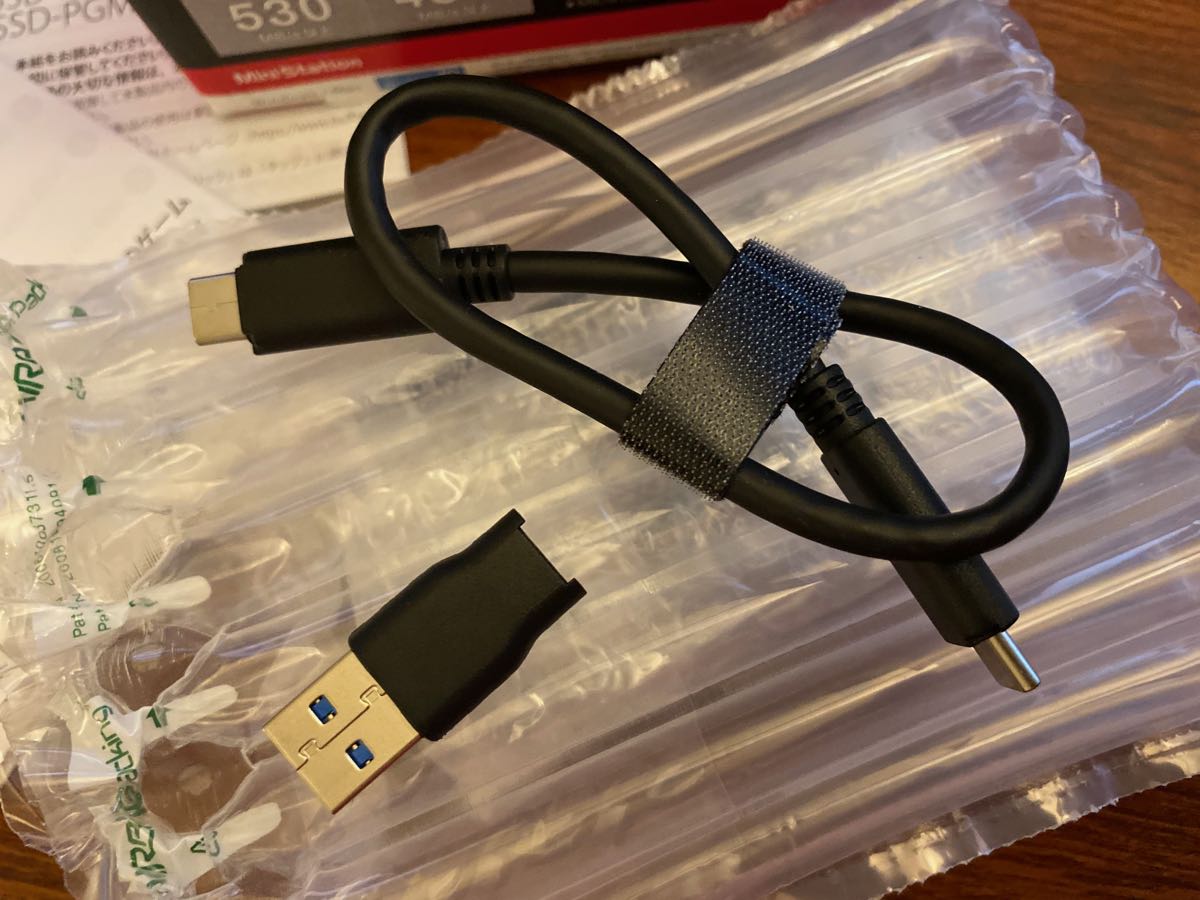 厳重に緩衝材に覆われた本体とUSB-Cケーブルとto USB-A変換アダプター